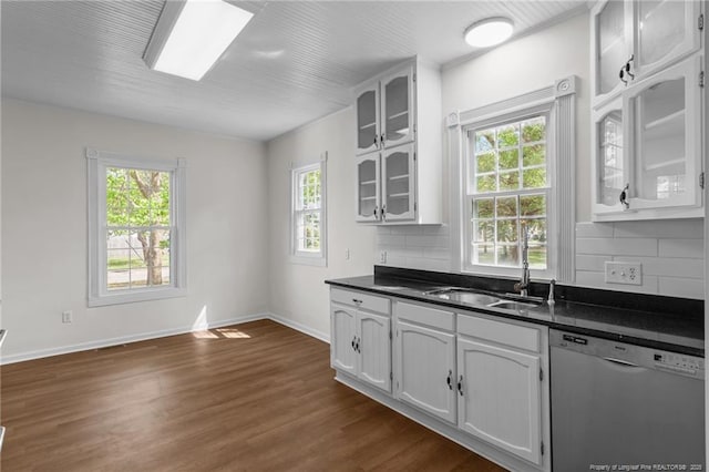 kitchen with a sink, dishwasher, white cabinets, and dark countertops