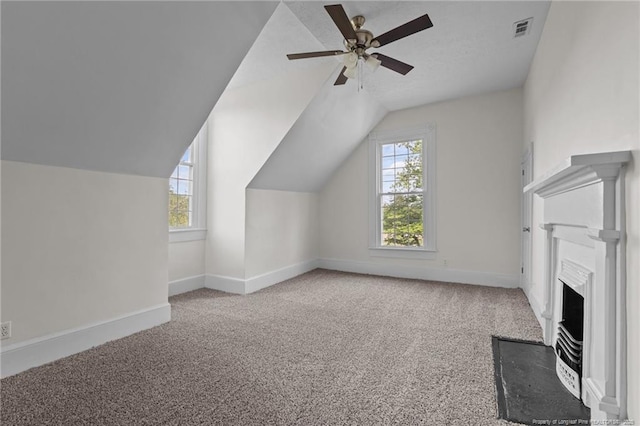 bonus room with carpet floors, a ceiling fan, baseboards, lofted ceiling, and visible vents