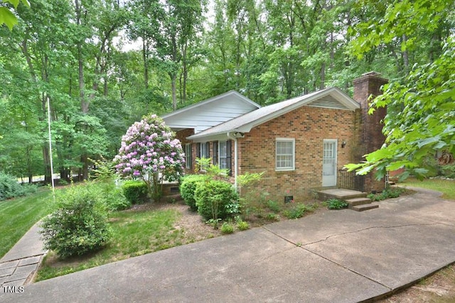 view of property exterior featuring a chimney and brick siding