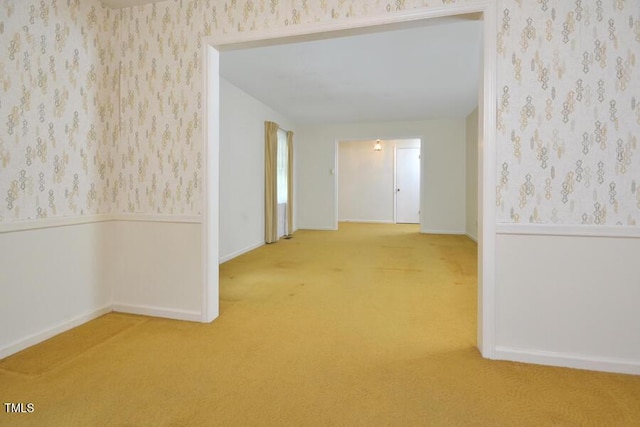 hallway featuring baseboards, carpet, and wallpapered walls