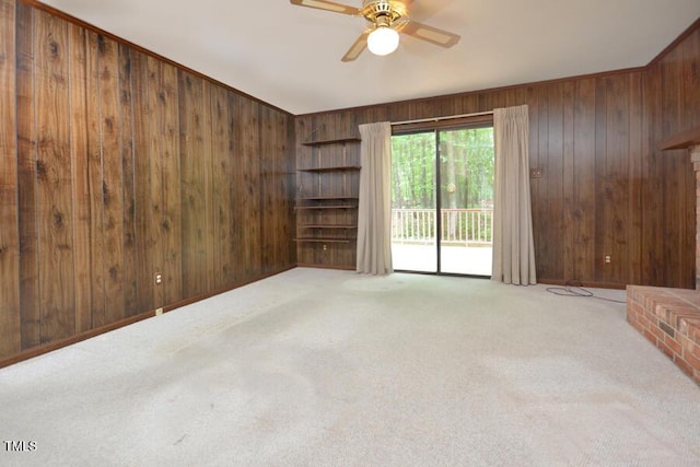 unfurnished room featuring wooden walls, ceiling fan, and carpet flooring