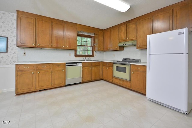 kitchen featuring electric stove, freestanding refrigerator, wallpapered walls, stainless steel dishwasher, and under cabinet range hood