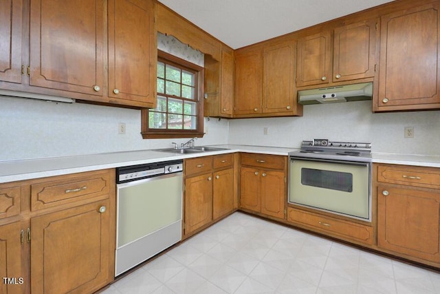 kitchen featuring electric range, a sink, dishwasher, light countertops, and under cabinet range hood