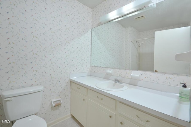 bathroom with walk in shower, vanity, toilet, wallpapered walls, and baseboards