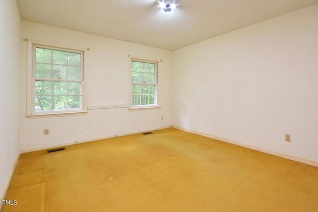 unfurnished room with carpet flooring, baseboards, and visible vents
