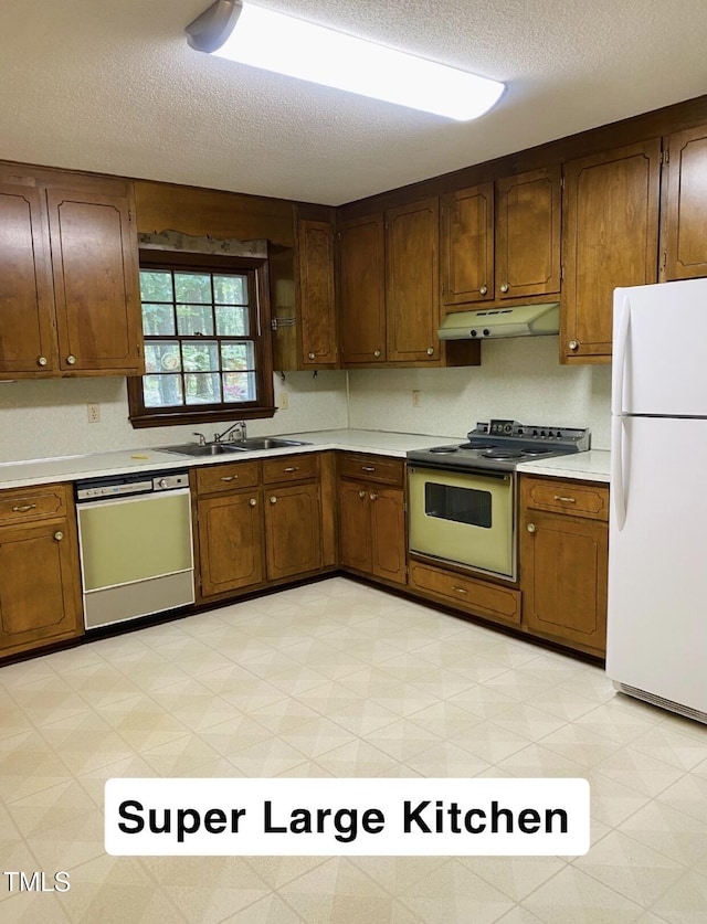 kitchen with range with electric cooktop, a textured ceiling, dishwasher, freestanding refrigerator, and under cabinet range hood