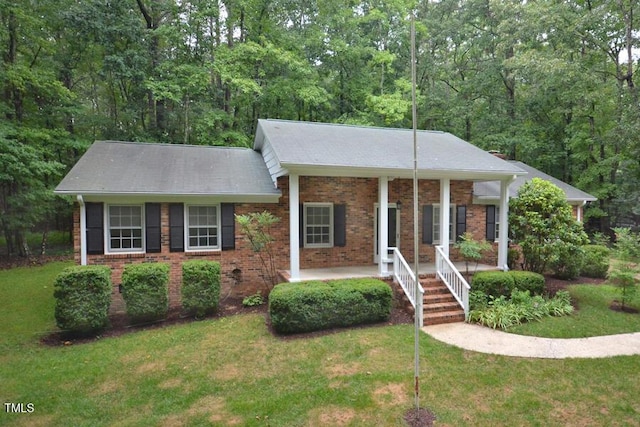 5825 Scalybark Rd, Durham, NC 27712 - ranch-style home featuring covered porch, a front yard, brick siding, and a view of trees