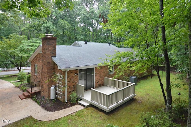 5825 Scalybark Rd, Durham, NC 27712 - back of property featuring a chimney, brick siding, a lawn, roof with shingles, and a deck