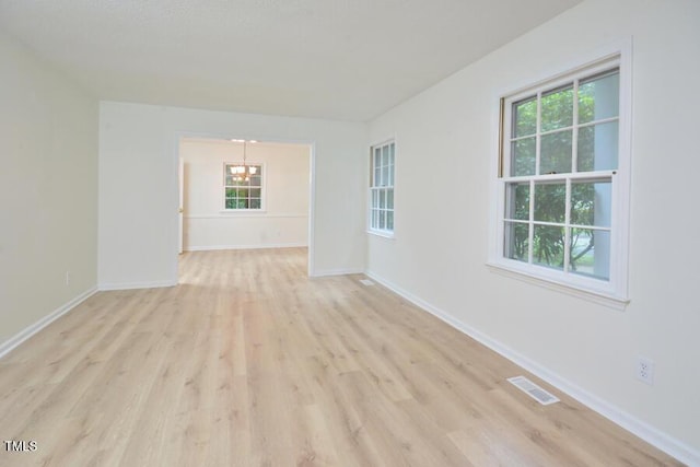 5825 Scalybark Rd, Durham, NC 27712 - empty room featuring a chandelier, light wood-type flooring, and healthy amount of natural light
