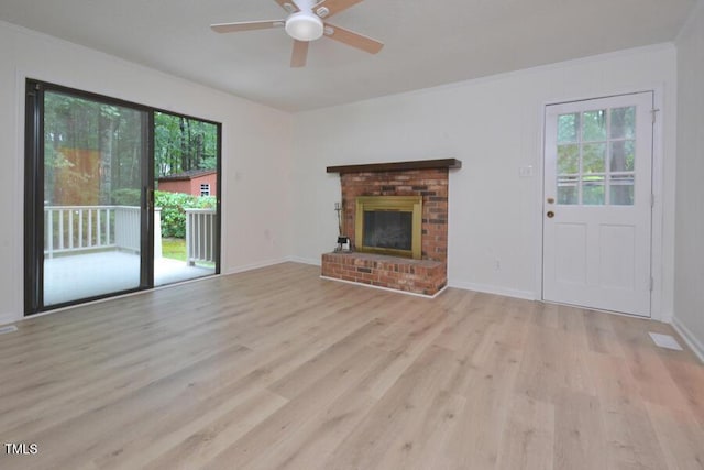 5825 Scalybark Rd, Durham, NC 27712 - unfurnished living room featuring a ceiling fan, light wood-style flooring, crown molding, and a brick fireplace