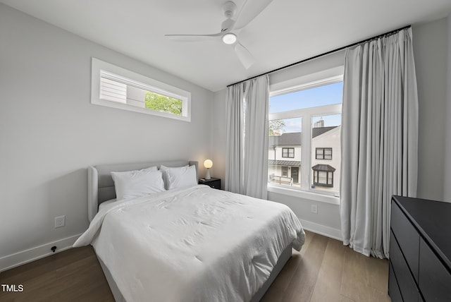 bedroom with baseboards, ceiling fan, and dark wood-style floors