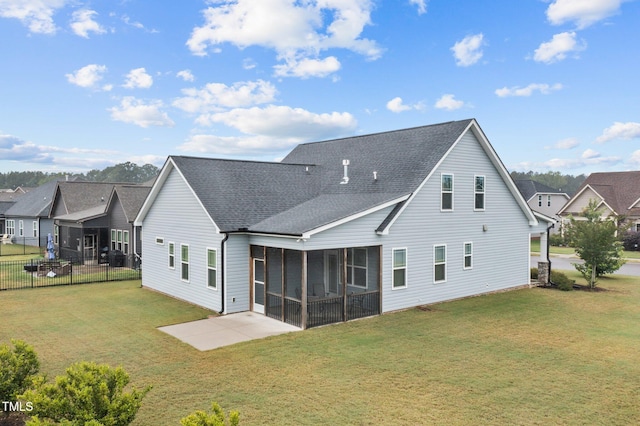 rear view of house with roof with shingles, fence, a sunroom, a patio area, and a lawn