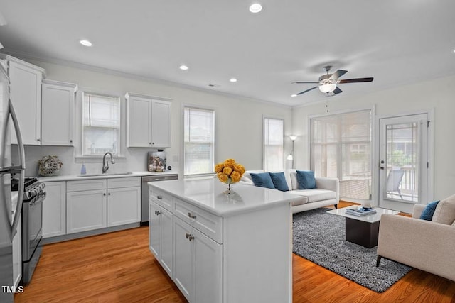 kitchen featuring ceiling fan, dishwasher, a sink, gas stove, and open floor plan