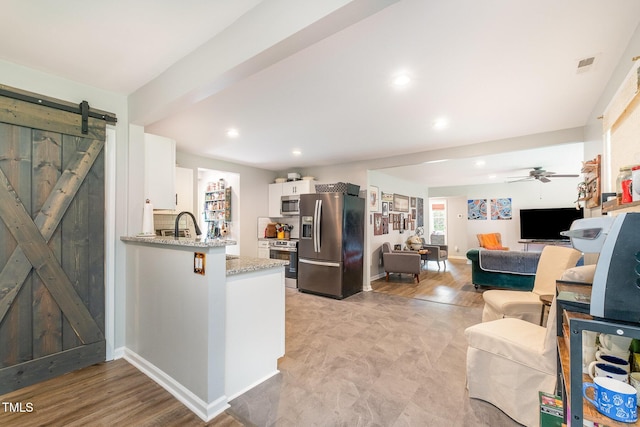 553 Isley Rd, Haw River, NC 27258 - kitchen with stainless steel appliances, a barn door, white cabinetry, light stone countertops, and ceiling fan