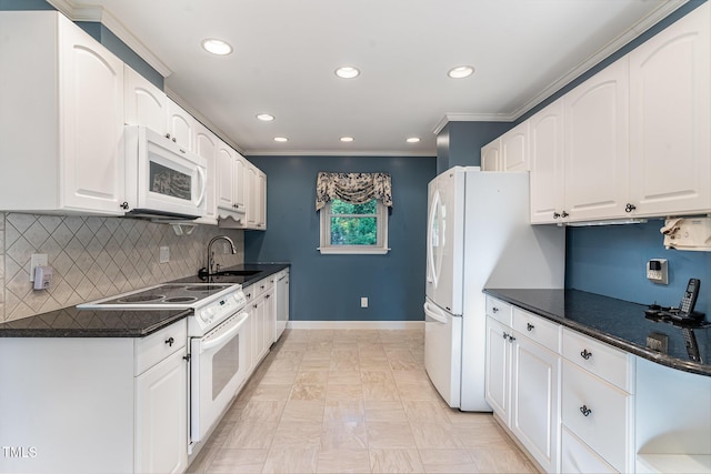 kitchen featuring decorative backsplash, dark countertops, white appliances, white cabinetry, and a sink