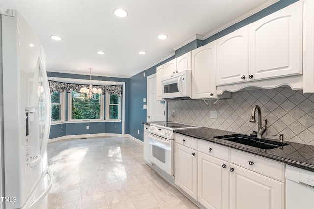 kitchen with a sink, baseboards, an inviting chandelier, white appliances, and white cabinetry