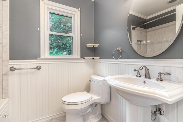 bathroom featuring toilet, walk in shower, wainscoting, and ornamental molding