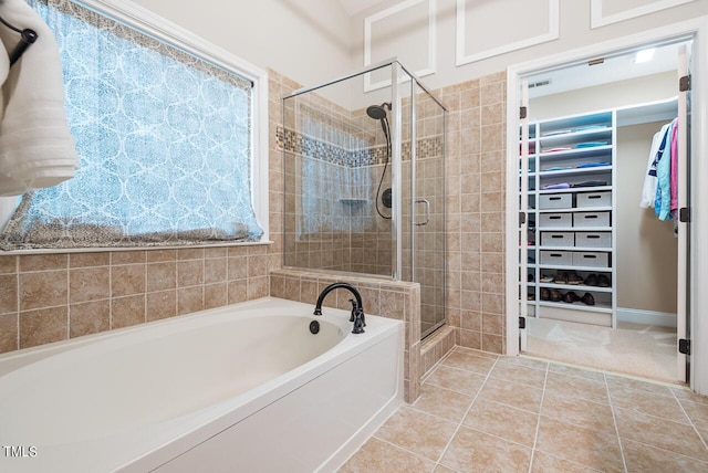 116 Dallavia Ct, Morrisville, NC 27560 - full bathroom featuring tile patterned floors, a walk in closet, a bath, and a stall shower