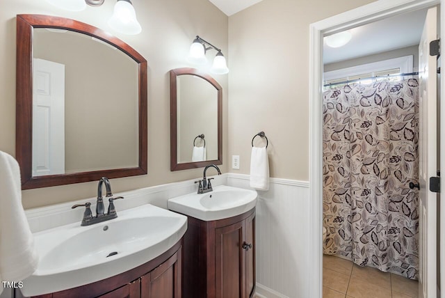 116 Dallavia Ct, Morrisville, NC 27560 - bathroom with two vanities, a sink, tile patterned flooring, and a wainscoted wall