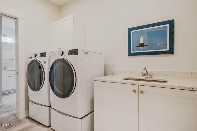 328 Boone St, Chapel Hill, NC 27516 - laundry area featuring separate washer and dryer, light wood-type flooring, and cabinet space