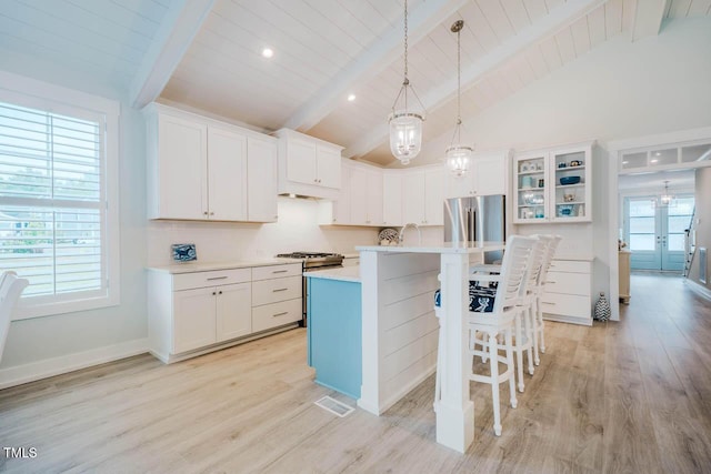 328 Boone St, Chapel Hill, NC 27516 - kitchen featuring beam ceiling, light countertops, a kitchen breakfast bar, light wood-style floors, and white cabinetry