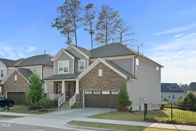 craftsman-style house with fence, covered porch, board and batten siding, concrete driveway, and an attached garage