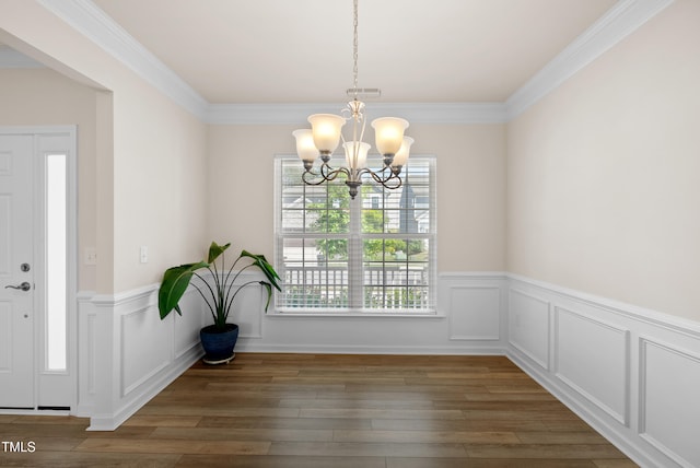 unfurnished dining area featuring wood-type flooring, a chandelier, wainscoting, and visible vents