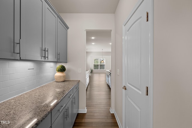 corridor with baseboards, recessed lighting, and dark wood-style flooring