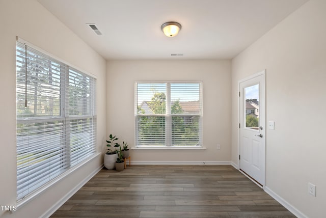unfurnished dining area featuring visible vents, plenty of natural light, and wood finished floors