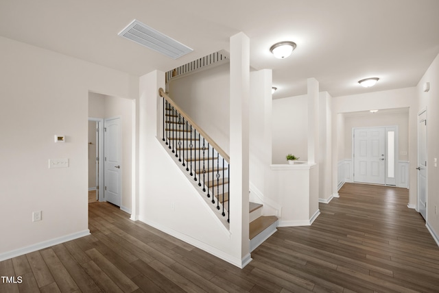 staircase featuring visible vents, baseboards, and wood finished floors