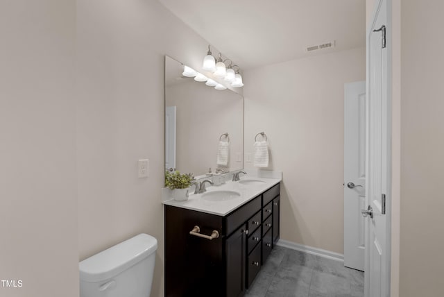 bathroom with visible vents, a sink, double vanity, and toilet