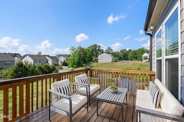 wooden deck featuring an outdoor living space, a yard, and a residential view