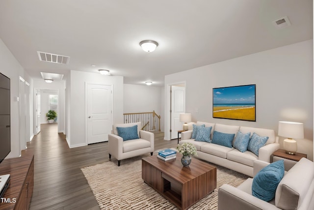 living room with dark wood-style flooring, baseboards, and visible vents