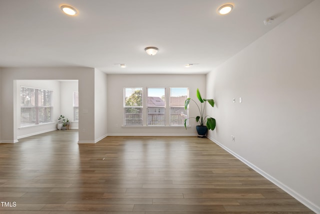 unfurnished living room with baseboards, recessed lighting, and wood finished floors