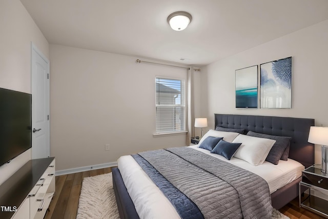 bedroom featuring baseboards and dark wood-style floors