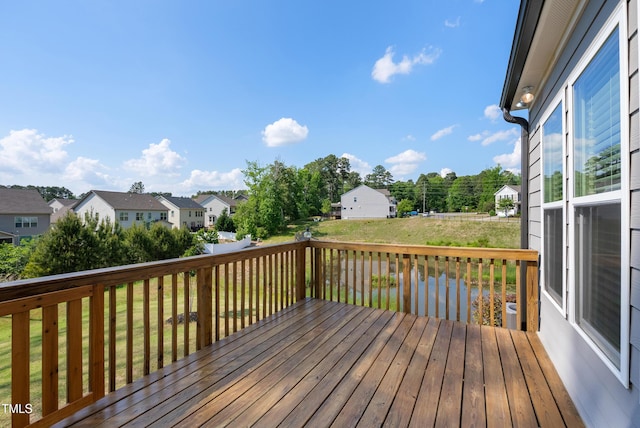 wooden deck featuring a yard and a residential view
