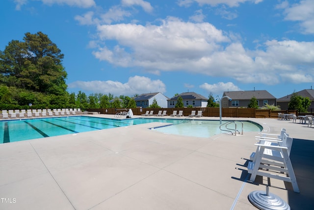 community pool featuring a patio and fence