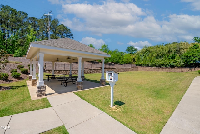 view of community with a lawn, fence, and a gazebo