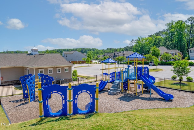 community jungle gym with fence and a lawn