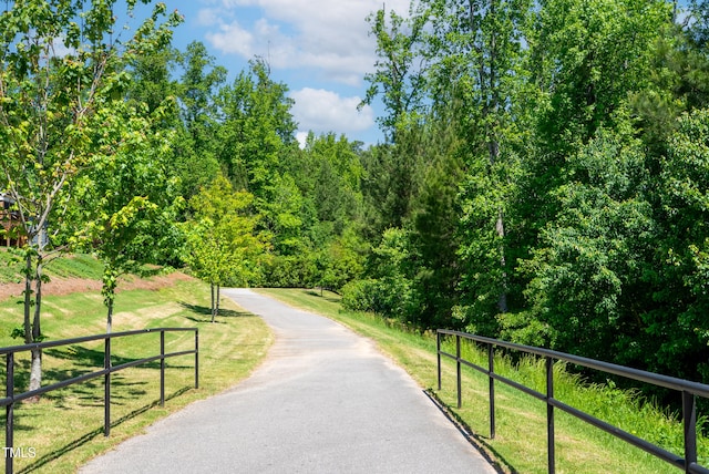 surrounding community with a yard and a wooded view