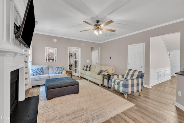 312 Grassy Point Rd, Apex, NC 27502 - living area featuring light wood-type flooring, a fireplace, ceiling fan, and crown molding