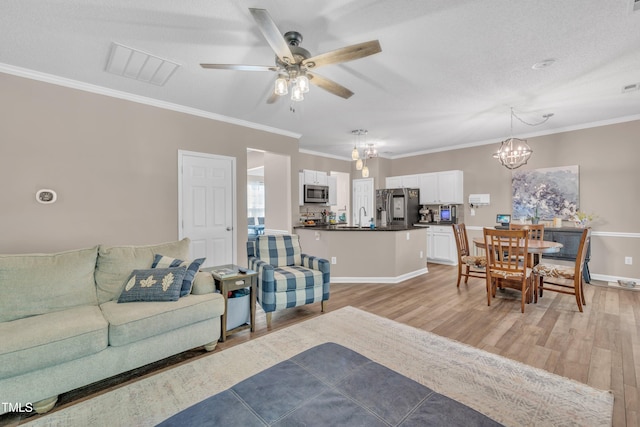 312 Grassy Point Rd, Apex, NC 27502 - living room with a chandelier, light wood finished floors, a ceiling fan, ornamental molding, and baseboards
