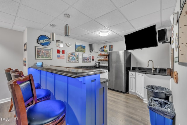 312 Grassy Point Rd, Apex, NC 27502 - kitchen with freestanding refrigerator, a peninsula, light wood-style flooring, a drop ceiling, and a kitchen bar