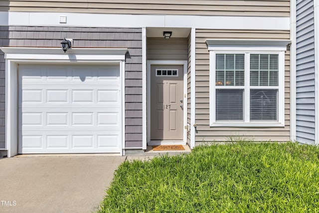 entrance to property with driveway and a garage