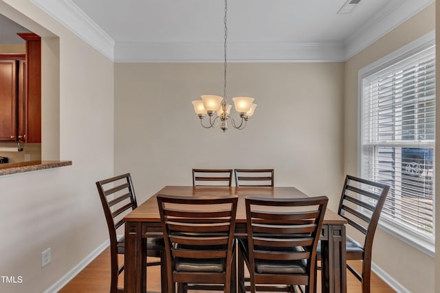 dining space with an inviting chandelier, ornamental molding, light wood-style flooring, and visible vents