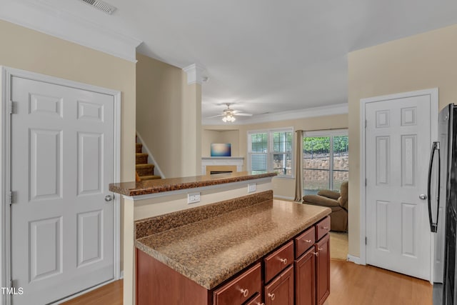 kitchen featuring freestanding refrigerator, open floor plan, ceiling fan, and light wood-style floors