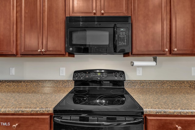 kitchen with brown cabinets, black appliances, and dark countertops