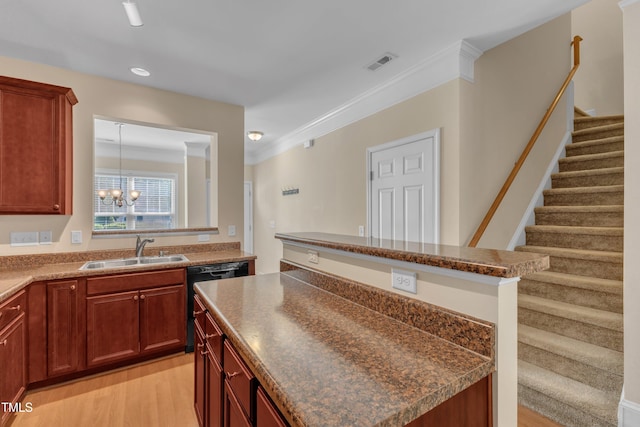 kitchen with a sink, dishwasher, light wood-style flooring, a kitchen island, and visible vents
