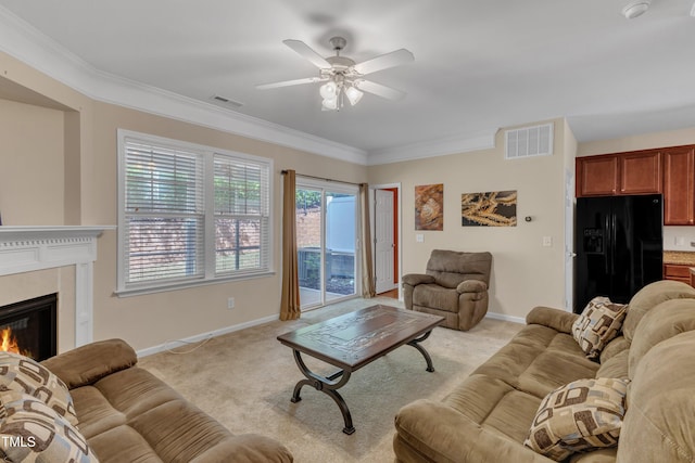 living area with visible vents, a ceiling fan, a high end fireplace, and light colored carpet