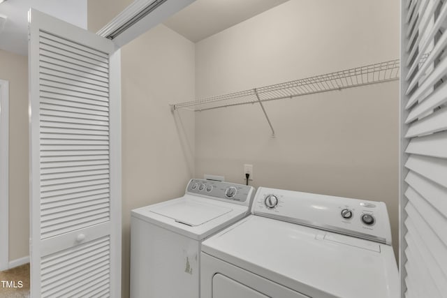 clothes washing area featuring laundry area, carpet flooring, and washing machine and clothes dryer